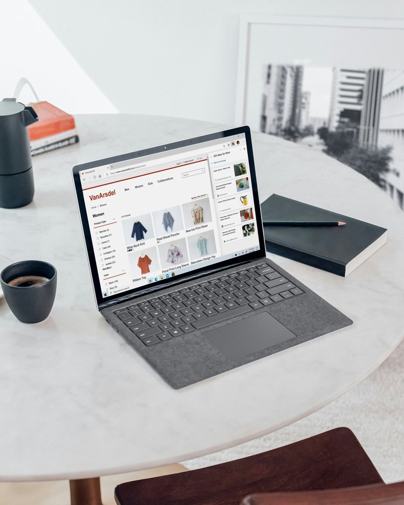 Laptop on a marble table showing an online clothing store